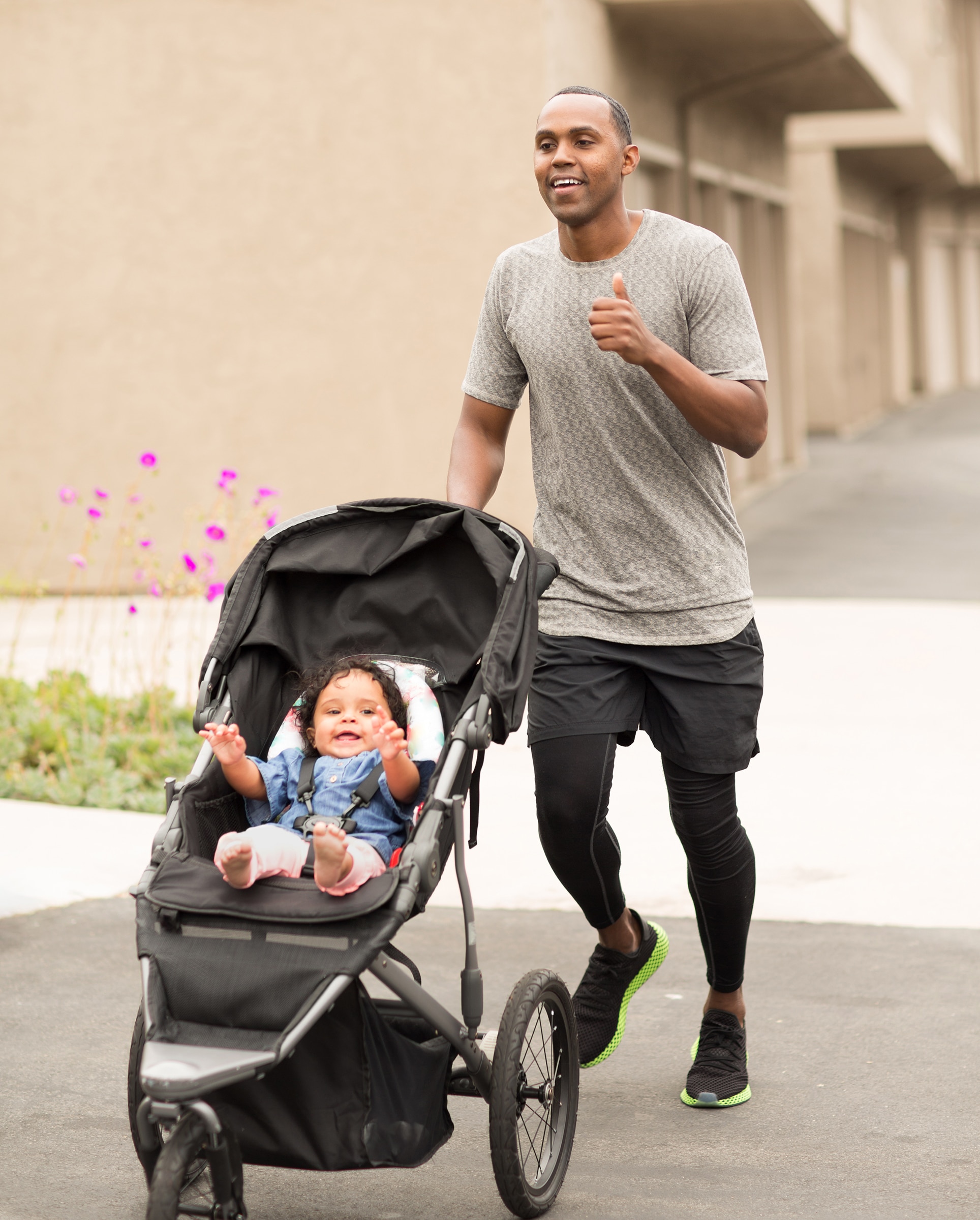 Dad out jogging with baby daughter in stroller
