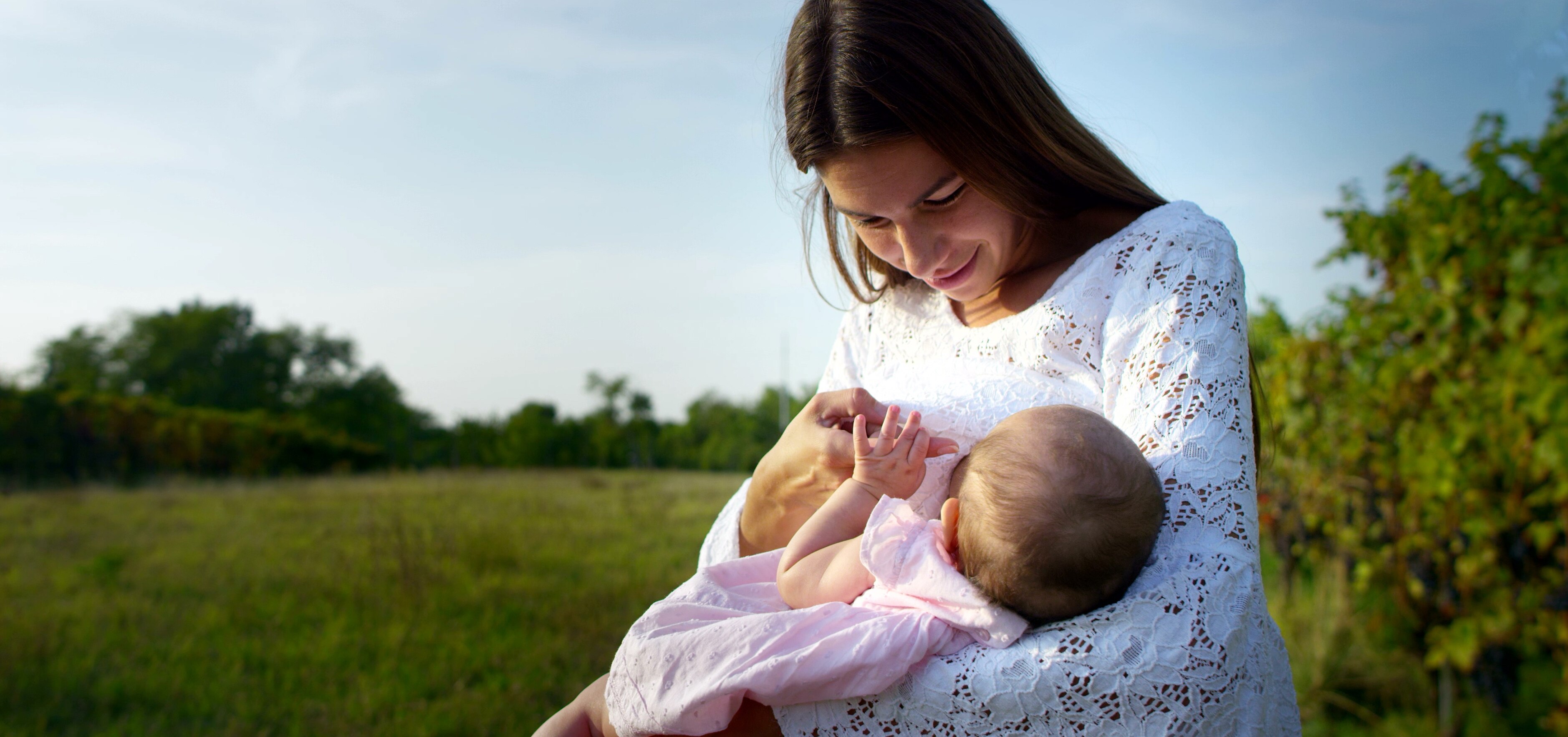 Mother breastfeeding her baby in nature