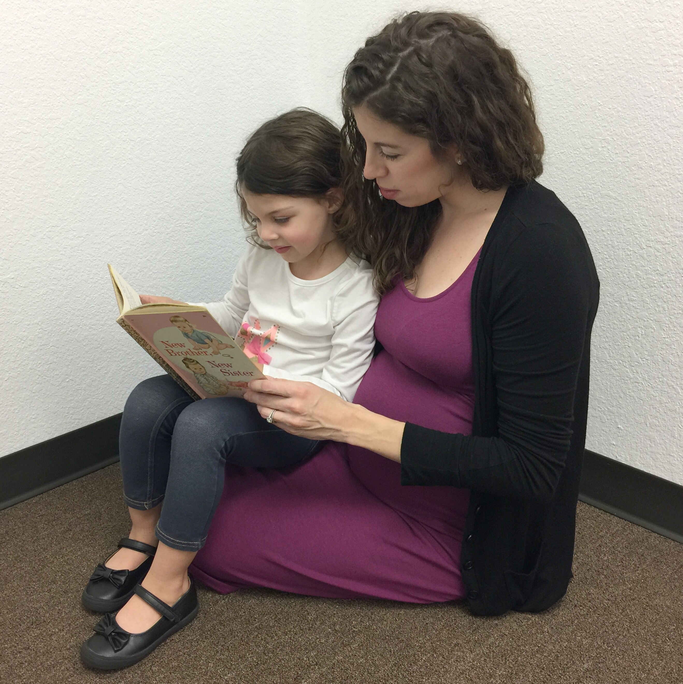 Mother reads to young daughter about becoming a big sister